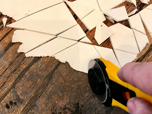 Cut shapes of white air dry clay with a rotary cutter to make terrazzo trays.